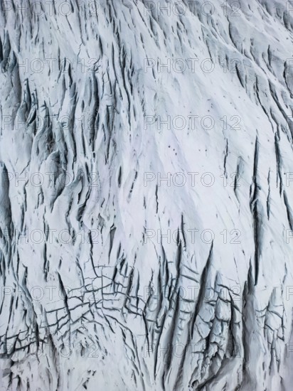 Aerial view of the Icelandic winter terrain, showcasing a dramatic, snow-covered landscape with intricate patterns carved by nature's force, highlighting the remote and wild beauty, Ã–rÃ¦fi, Austurland, Islandia