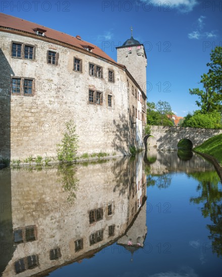The moated castle of Kapellendorf is reflected in the water of the moat, Thuringia, Germany