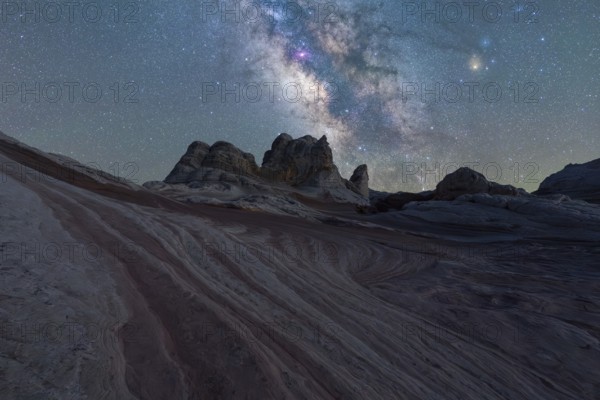 Vivid Milky Way illuminates the striped rock formations in the Utah desert under a starry sky