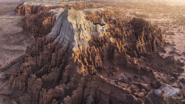 Stunning aerial photograph captures the intricate, erosion-sculpted rock formations of Goblin Valley State Park in Utah, USA, bathed in the warm glow of a sunset