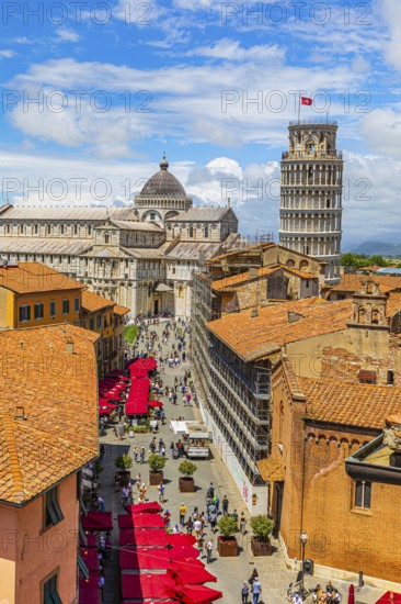 Above the rooftops of Pisa, behind the Cathedral of Santa Maria Assunta and the Leaning Tower, Via Santa Maria, Pisa, Tuscany, Italy