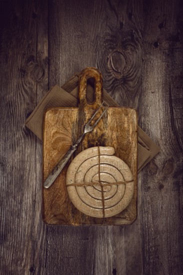 Raw spiral sausages, on a wooden board, top view, no people