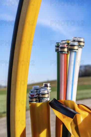 Fibre optic connection, empty conduits protrude from the ground along a dirt track, into which the actual fibre optic cable is later blown and connected to the respective house connection or distributor, provision of fast Internet in rural areas, in the south of Mülheim an der Ruhr, North Rhine-Westphalia, Germany