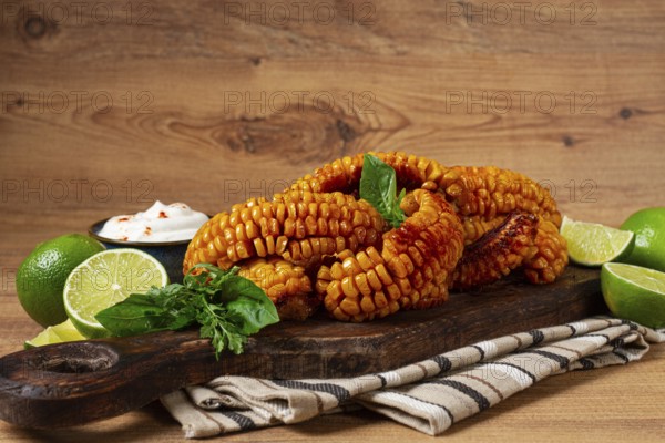 Corn ribs, with cream sauce, spices and lime, appetizer, on a wooden cutting board, homemade, no people