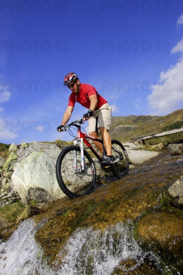 A man on a mountain bike in an alpine landscape