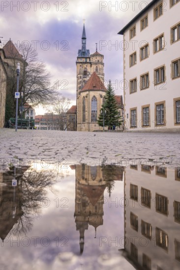 Reflection of a church in a puddle with a cloudy sky, collegiate church Stuttgart, Germany