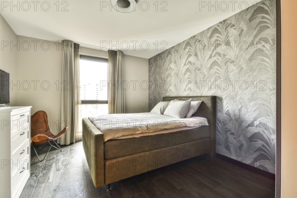 A stylish and contemporary bedroom featuring a cozy bed, elegant decor, and large windows that provide natural light, creating a serene atmosphere