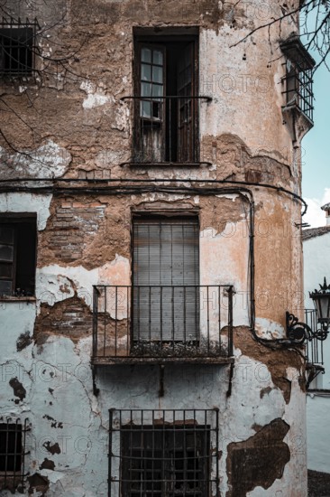 Dilapidated building with weathered balconies and shutters
