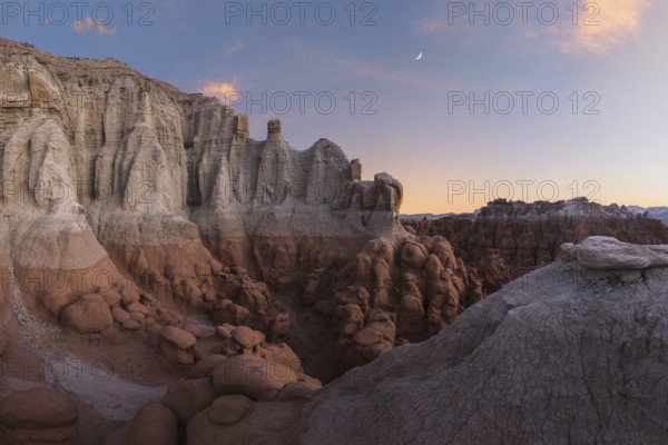 Scenic view of unique sandstone formations at Goblin Valley State Park in Utah during sunset, showcasing natural beauty and geological wonder in a serene setting
