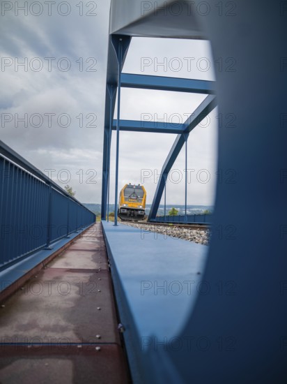 Yellow train through steel bridge taken from an unusual angle, track construction, rail delivery for Hermann Hessebahn, Calw, Black Forest, Germany