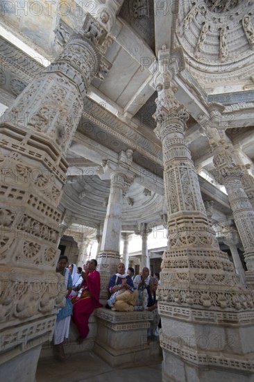 Indian woman praying between the white marble pillars in the Adinath temple in Ranakpur, Jain temple, Rajasthan, India