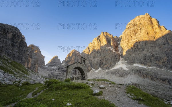 Cappella Ai Brentei chapel Memorial for injured mountaineers at the Rifugio Ai Brentei mountain hut, rocky peaks at sunrise with alpine glow, picturesque mountain landscape, Brenta, Trentino, Italy