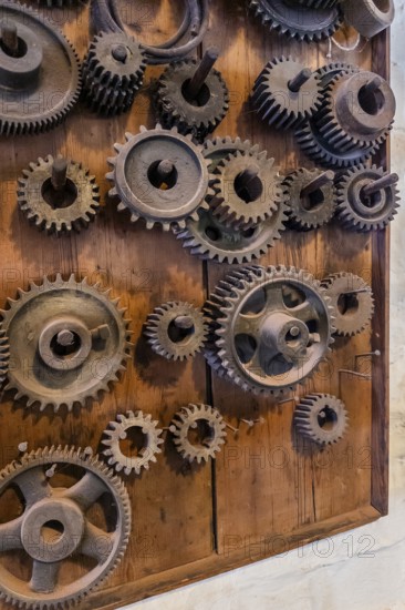 Bramsche, Lower Saxony, Germany, Various cogwheels mounted on a wooden board