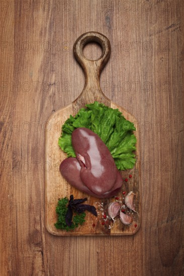 Raw pork kidneys, on a chopping board, close-up, top view, no people