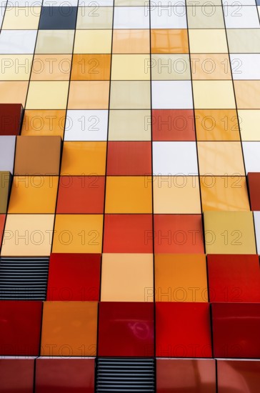 Close-up view of a vibrant and multi-colored tiled facade of a building in Hong Kong. The image showcases a spectrum of colors arranged neatly in squares, offering a modern architectural aesthetic
