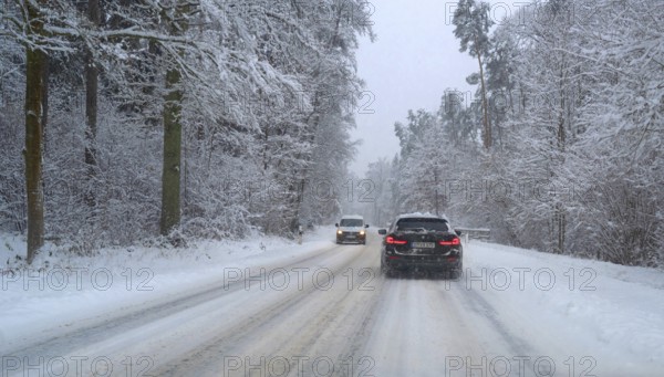 Cars on winter road in snowy forest, Erlangen, Middle Franconia, Bavaria, Germany