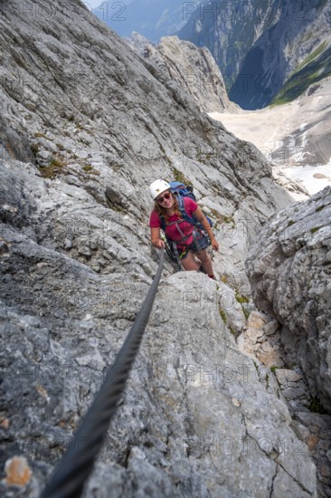 Mountaineer with helmet climbing in a secured via ferrata, Zugspitze via ferrata, ascent to the Zugspitze, Wetterstein range, Wetterstein range, Bavaria, Germany