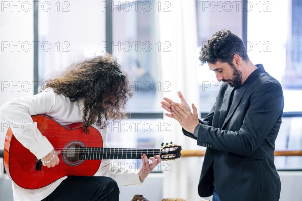 Man applauding to popular guitarist playing bass guitar in studio