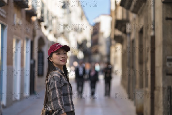 Asian female tourist enjoying a stroll through the historic streets of Avila, capturing the essence of the medieval walls and the rich cultural heritage of the area