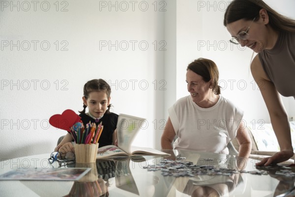 A joyful family moment with a girl with a tracheostomy engaging in art and puzzles, surrounded by supportive family members, showcasing love and creativity