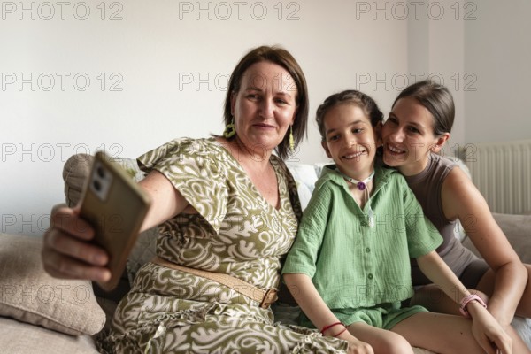 A family enjoying quality time together. A young girl with a tracheostomy smiles warmly with her family, while taking a selfie together