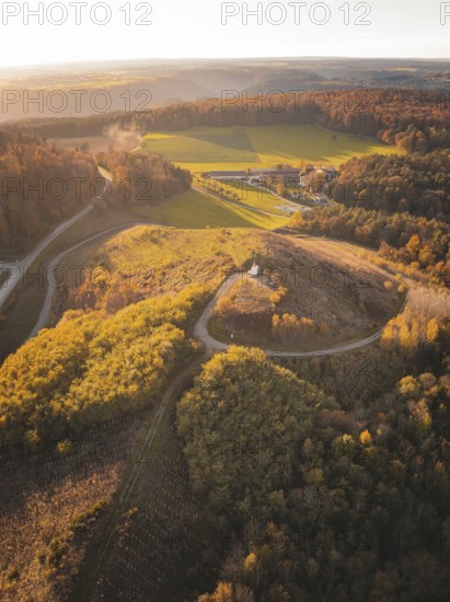 Aerial view of hills and fields surrounded by autumnal forests, Lindenrain industrial estate, Gechingen, Black Forest, Germany