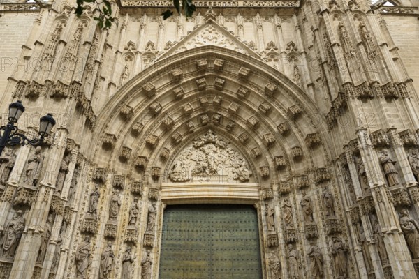 Elaborately decorated Gothic entrance door with detailed architectural elements, Seville, Andalusia, Spain