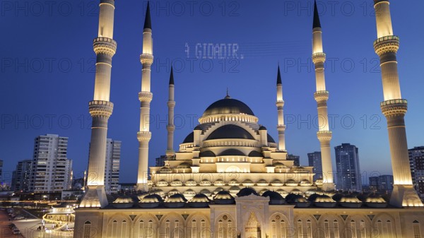 Aerial view captures hundreds of Muslims gathered at long tables for a communal Iftar meal in a festively decorated square outside a large mosque in Gaziantep, Turkey on March 11, 2026, Gaziantep, Turkey