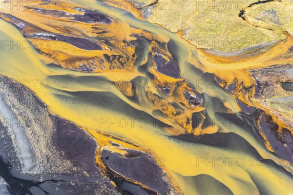 Stunning aerial capture of Iceland's golden rivers winding through vibrant landscapes, showcasing a mixture of colors and natural patterns