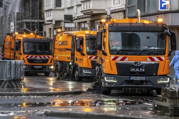 Sweeping on Rose Monday in Düsseldorf, the municipal utilities clean up after the train, confetti, camels, trash, employees with sweepers from AWISTA, Society for Waste Management and City Cleaning, central disposal and urban cleaning companies in Düsseldorf, clean the train's path with their street cleaning machines, North Rhine-Westphalia, Germany