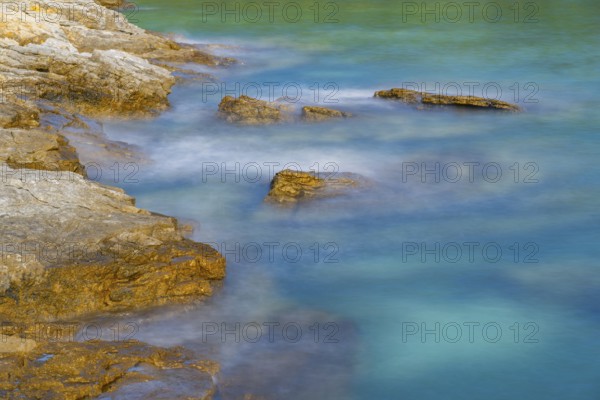 Crystal clear and turquoise water on the beach of Ustrine Bay on a sunny day on the island of Cres, long exposure, Croatia