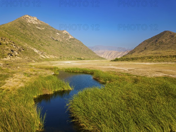 Landscape in Oman, mountains, Wadi Ashawq, road, reeds, waters Salalah, Al Mughsyal / Wadi Ashawq, Dhofar, Oman