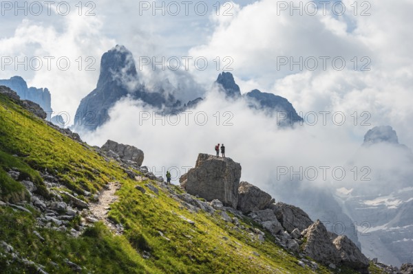 Alpine panorama, mountaineers on a large rock, fog and Torre Di Brentai and Cima Tosa, rocky mountain peaks and mountain landscape, Brenta Mountains, Parco Naturale Brenta-Adamello, Trentino, Italy