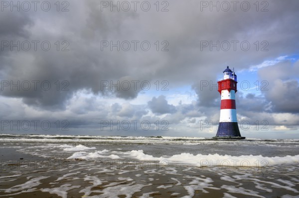 The lighthouse Roter Sand in front of blue sky with cumulus clouds and surf waves, Weser estuary, Bremen, Federal Republic of Germany