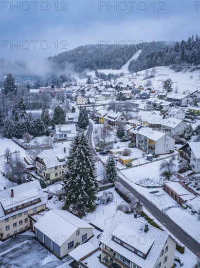 Aerial view of a snow-covered village surrounded by forests and mountains in winter, Enzklösterle, Calw district, Black Forest, Germany