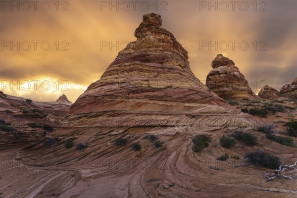 Vibrant sunset illuminates the swirling sandstone formations of Coyote Buttes in the Paria Canyon-Vermilion Cliffs Wilderness, Arizona, highlighting the dramatic landscape and dynamic skies