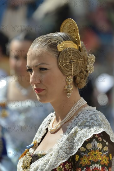 Fallas festival, woman in a traditional costume during the parade in the Plaza de la Virgen de los Desamparados, Valencia, Spain