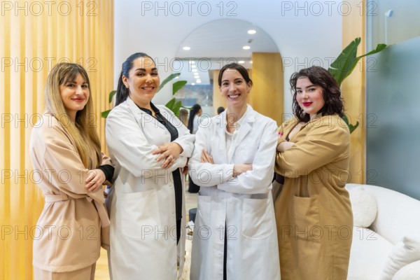 Group of confident women, including doctors and staff, standing with arms crossed and smiling at the camera in the reception area of a stylish skincare and beauty center