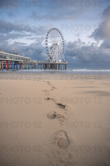 Footprints in the sand to the Ferris wheel at the pier, The Hague, Netherlands