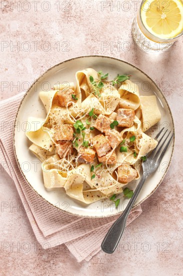Tagliatelli pasta, with salmon slices and herbs, on a decorative plate, homemade, no people