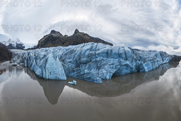 Captivating view of the expansive Vatnajökull Glacier, reflecting in calm waters at Vatnajökull National Park, Iceland, showcasing nature's tranquility and grandeur