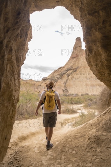 Vertical photo of a man walking along a path in the desert