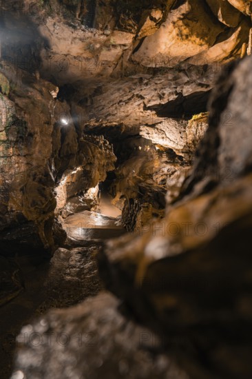 A mysterious cave trail with dramatic lighting and rock formations, St. Beatus Caves, Switzerland