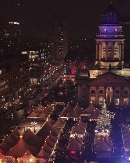 Aerial view of an illuminated Christmas market at Gendarmenmarkt at night with distinctive buildings in the background, Berlin