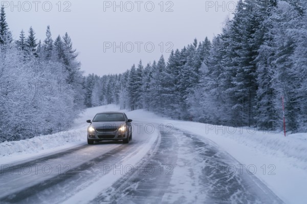 A car drives along a snow-covered road, flanked by dense, snow-laden trees in the serene Swedish Lapland landscape, capturing the essence of winter driving