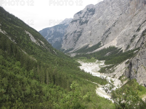 Extensive view of a wooded valley with a meandering river, hiking through the Reintal valley to the Zugspitze