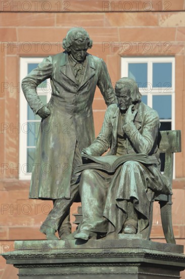 Brothers Grimm national monument, standing Jacob and sitting on the chair Wilhelm, brothers, bronze sculpture, poet, two, book, reading, free-standing, German Fairy Tale Route, market place, Hanau, Hesse, Germany