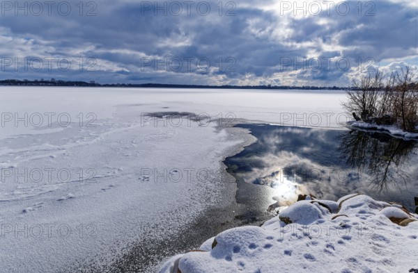 View of Schaalsee, covered with ice and snow, on the bridge tour, a hiking trail around Lake Kirchensee, in the UNESCO Schaalsee Biosphere Reserve. Zarrentin, Mecklenburg-Western Pomerania, Germany