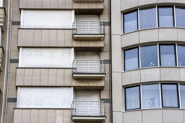 Facades of residential buildings on Zeedijk-Knokke, beach promenade in Knokke-Heist, largely uninhabited in winter, on the North Sea beach, dreary winter day, mostly apartment buildings with rental or condominiums, high-rise buildings on the street, Belgium