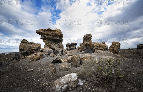 Eroded rock formations in volcanic landscape with dramatic cloudy skies, Ciudad Estratificada or Los Roferos, Antigua Rofera de Teseguite, Lanzarote, Canary Islands, Spain